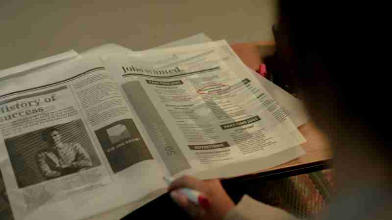 Person reviewing job listings in a newspaper, holding a pink marker for highlighting job ads., tags: im saarland leicht - pexel