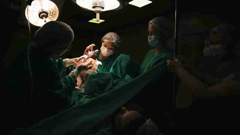 Doctors and nurses delivering a newborn baby under surgical lights in a hospital., tags: kliniken im saarland geburtshilfe und - pexel